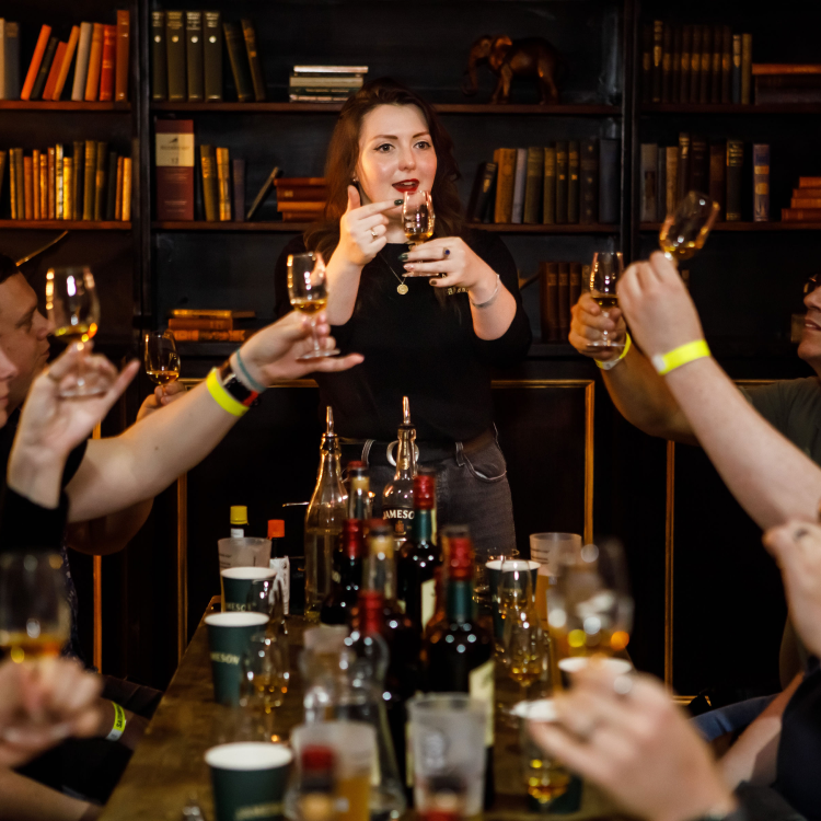 A group of people at a whiskey tasting being instructed by a professional Jameson Irish Whiskey guide