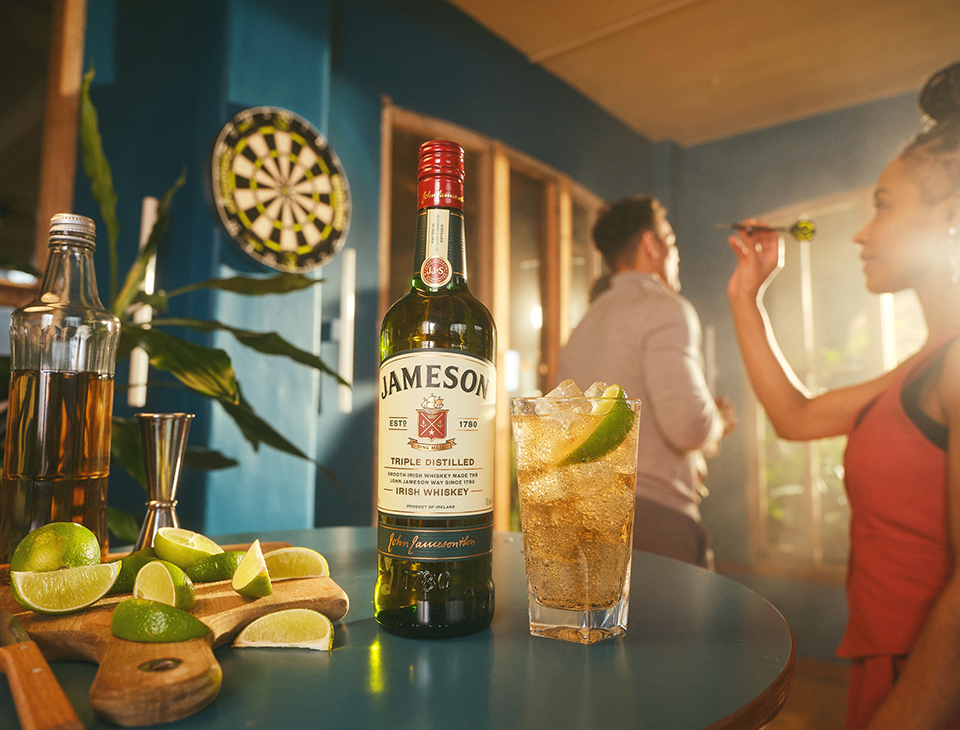 Friends playing darts and chatting while enjoying a Jameson, ginger and lime