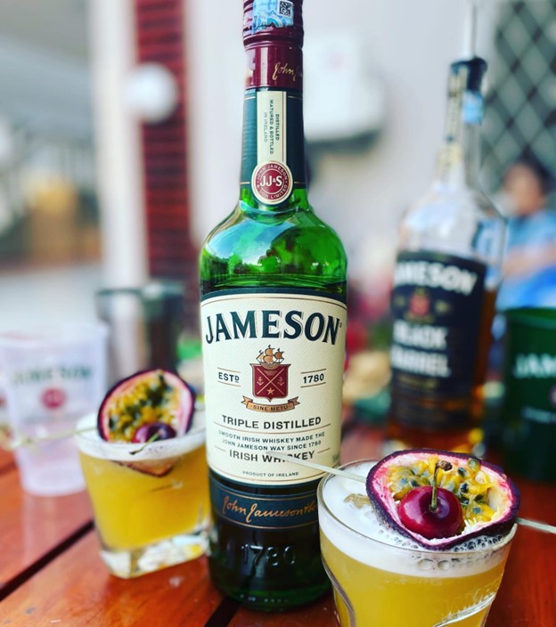 two jameson irish whiskey cocktails with fruit skewer garnishes
