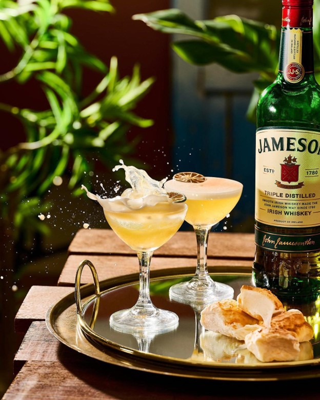 two cocktails made with jameson irish whiskey garnished with smoked citrus wheels