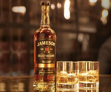 Bottle of Jameson Select Reserve with two tumbler glasses sitting on a bar top